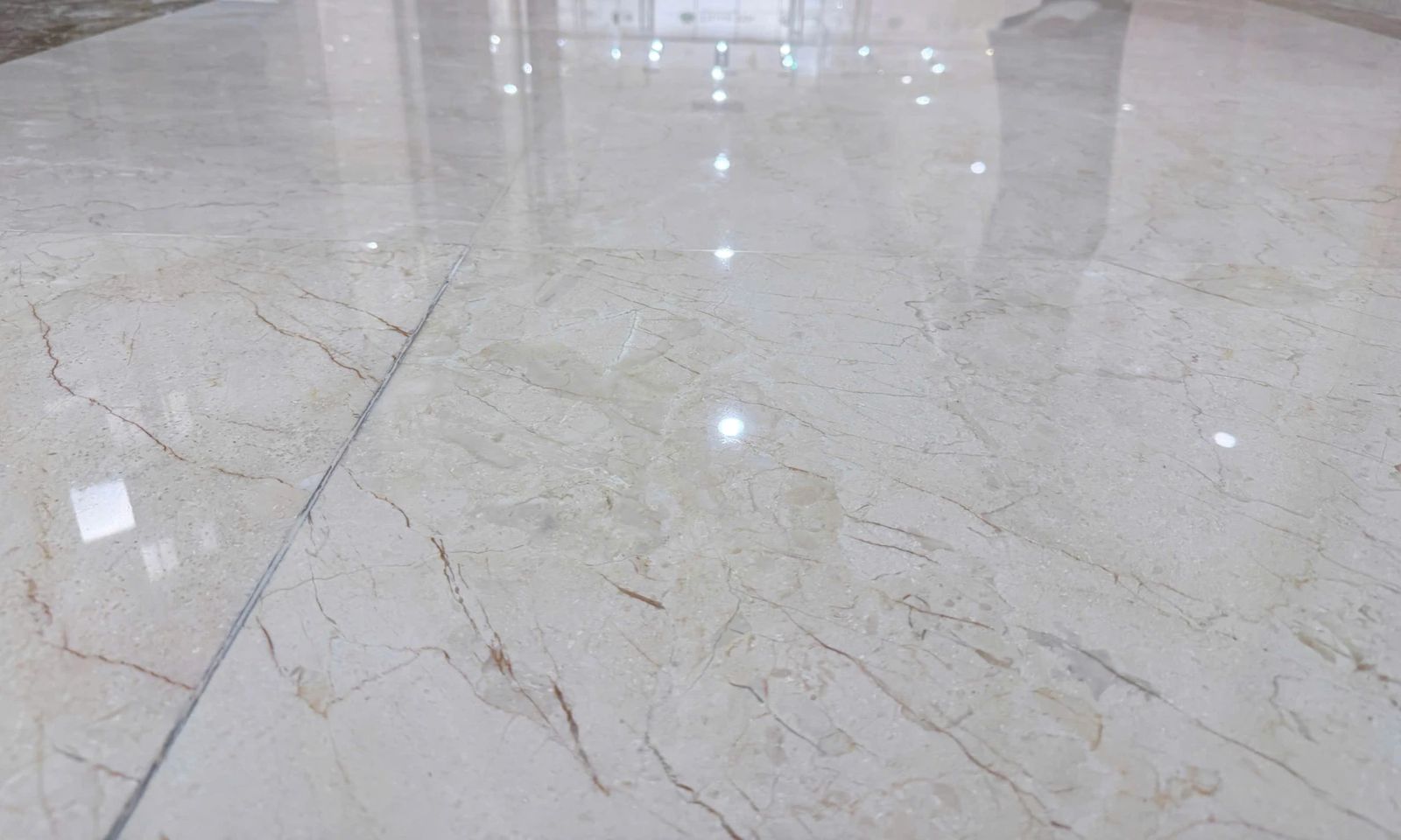 Sàn marble màu be sau khi đánh bóng, phản chiếu ánh đèn